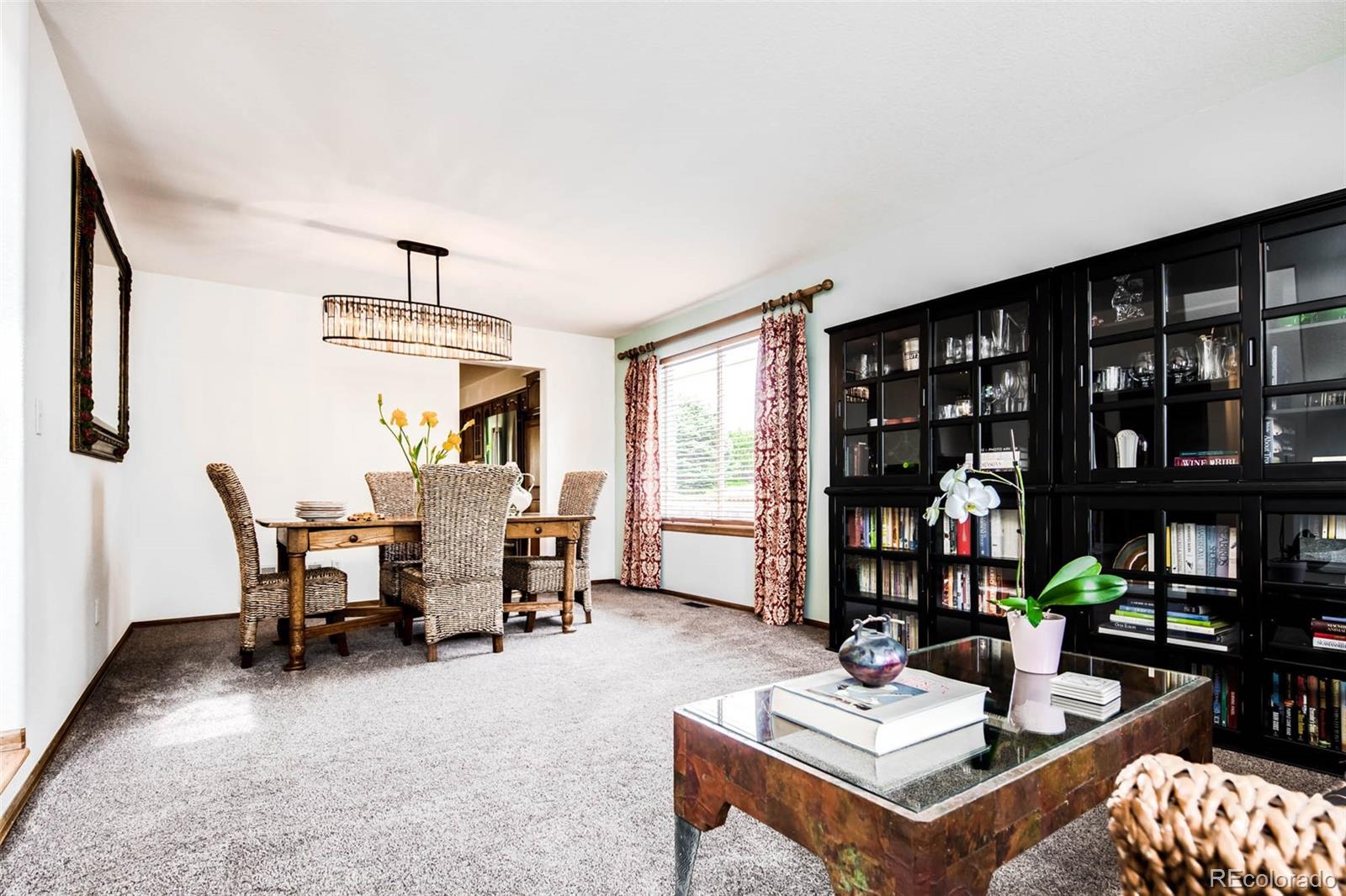 6549 Poppy Street Arvada, CO 80007 - Photo 3 of 33 a living room with furniture a bookshelf and a window
