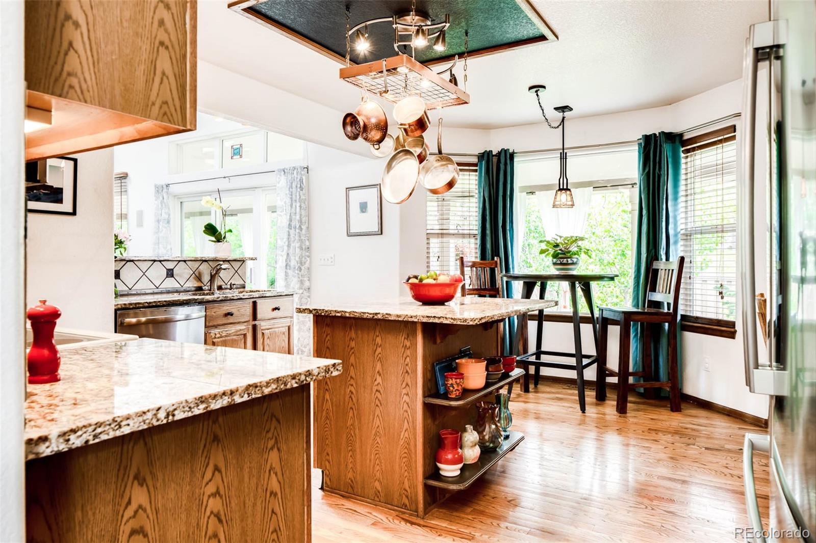 6549 Poppy Street Arvada, CO 80007 - Photo 6 of 33 a kitchen with stainless steel appliances granite countertop a stove and refrigerator