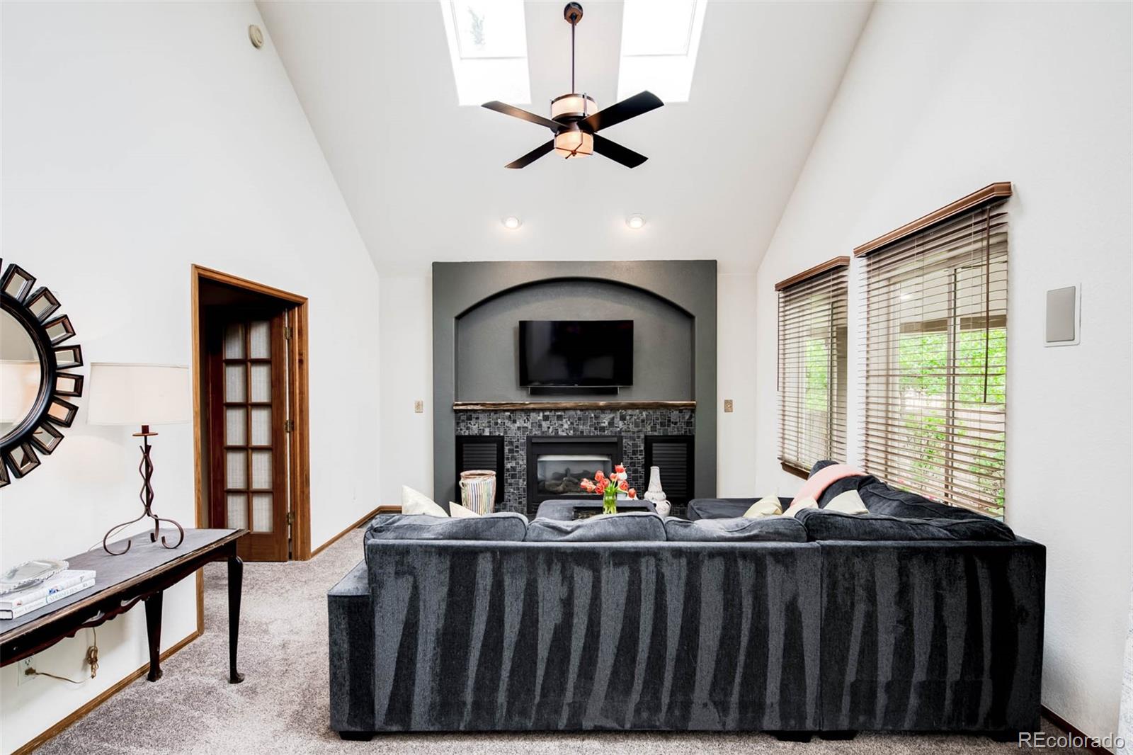 6549 Poppy Street Arvada, CO 80007 - Photo 10 of 33 a living room with furniture a fireplace and a flat screen tv