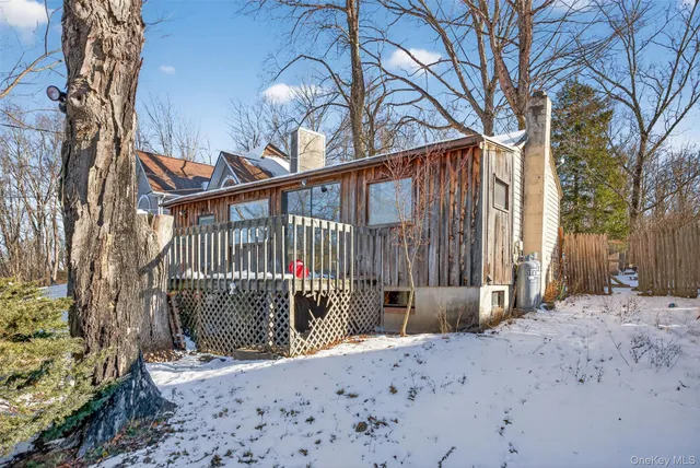 a view of a backyard with wooden fence and large trees