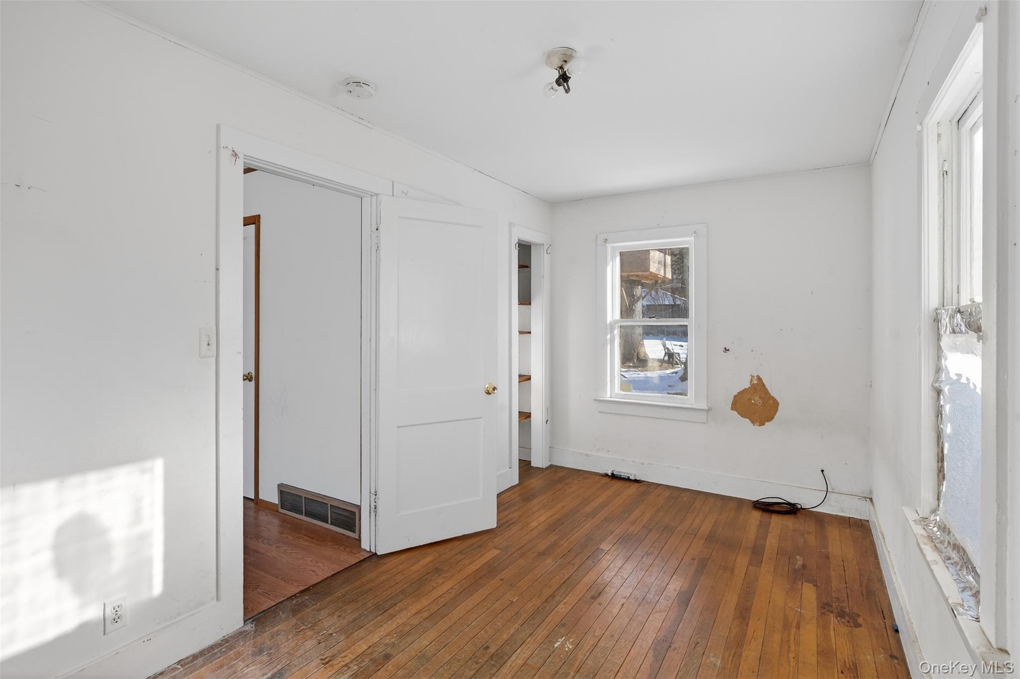 488 Tally Ho Road Middletown, NY 10940 - Photo 8 of 16 a view of an empty room with wooden floor and a window