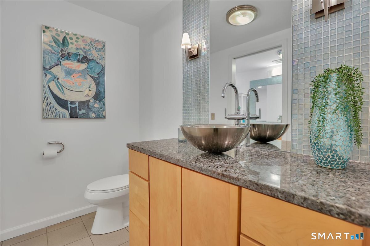 122 Ridgeview Circle Guilford, CT 06437 - Photo 19 of 40 An updated second full bath with tile flooring, vessel sink vanity (divided area with a second vanity), built-ins, tub, and walk-in shower.
