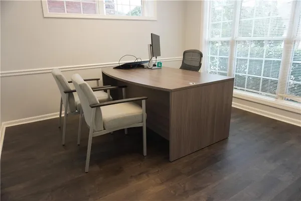 a view of a workspace with furniture and window