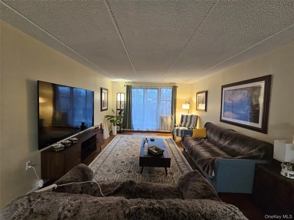 a living room with furniture flat screen tv and a window