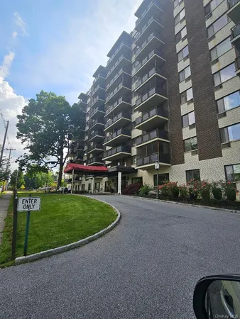 a view of a big building with a big yard and large trees