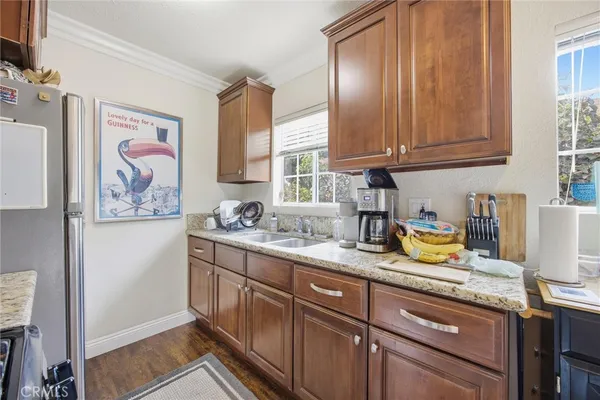 a kitchen with granite countertop cabinets stainless steel appliances a sink and a window