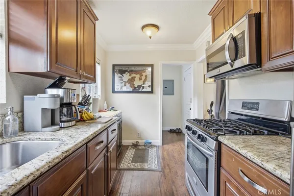a kitchen with stainless steel appliances granite countertop a sink stove and refrigerator