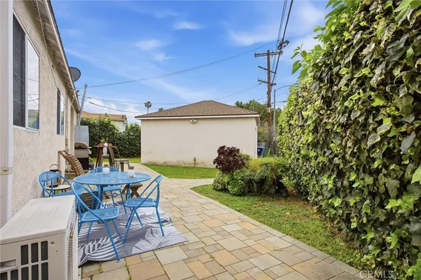 a view of a patio with table and chairs and potted plants with wooden fence