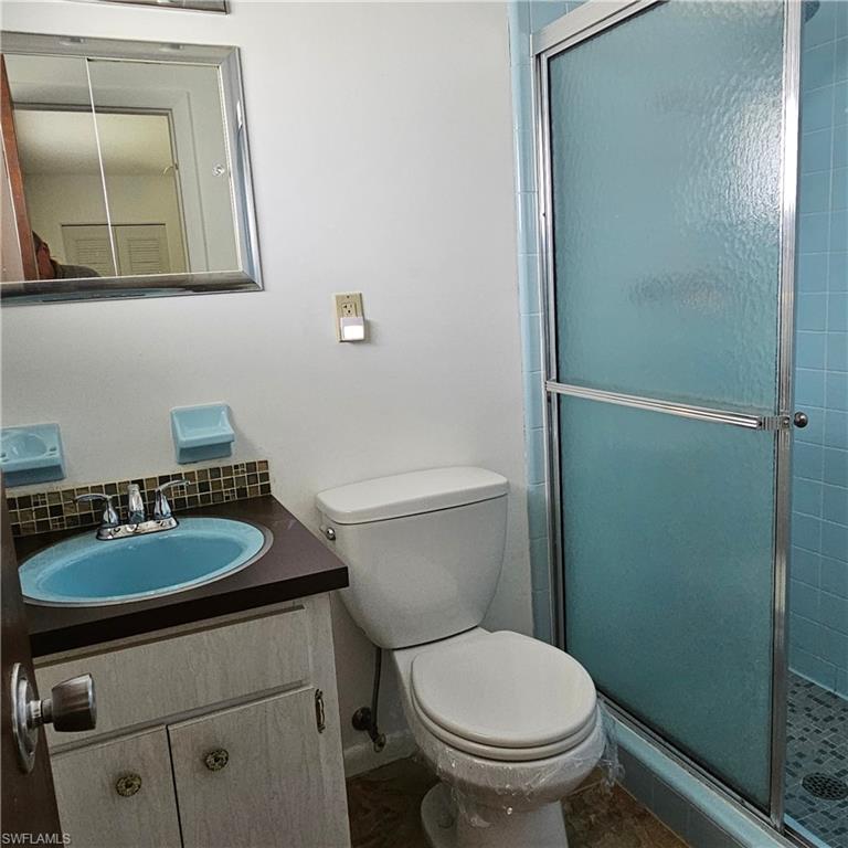 317 Maycrest Road Lehigh Acres, FL 33936 - Photo 5 of 5 a bathroom with a granite countertop toilet a sink and a mirror