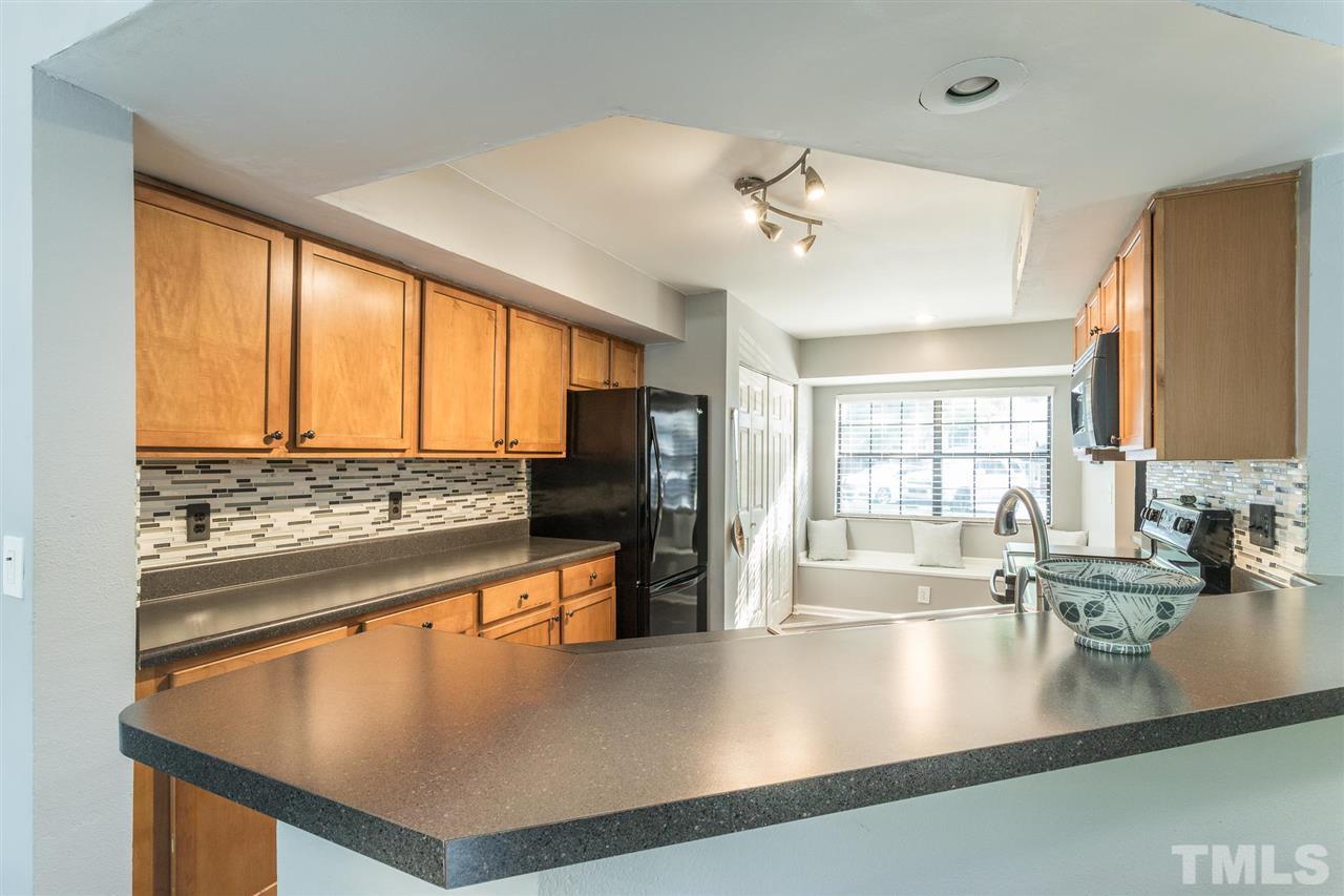 7615 Falcon Rest Circle, Unit 7615 Raleigh, NC 27615 - Photo 16 of 26 a kitchen with stainless steel appliances granite countertop a sink a stove and a refrigerator