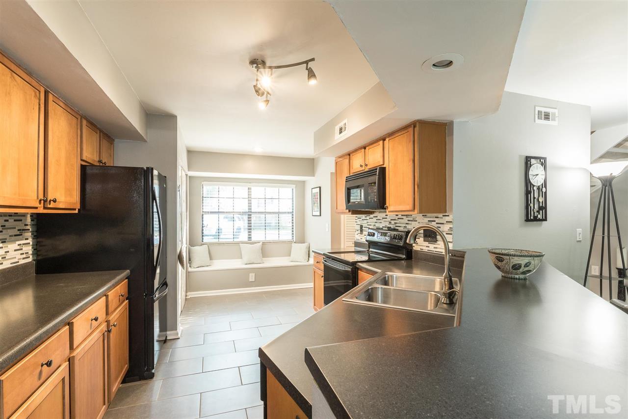 7615 Falcon Rest Circle, Unit 7615 Raleigh, NC 27615 - Photo 17 of 26 a large kitchen with stainless steel appliances a large counter top a stove and a refrigerator