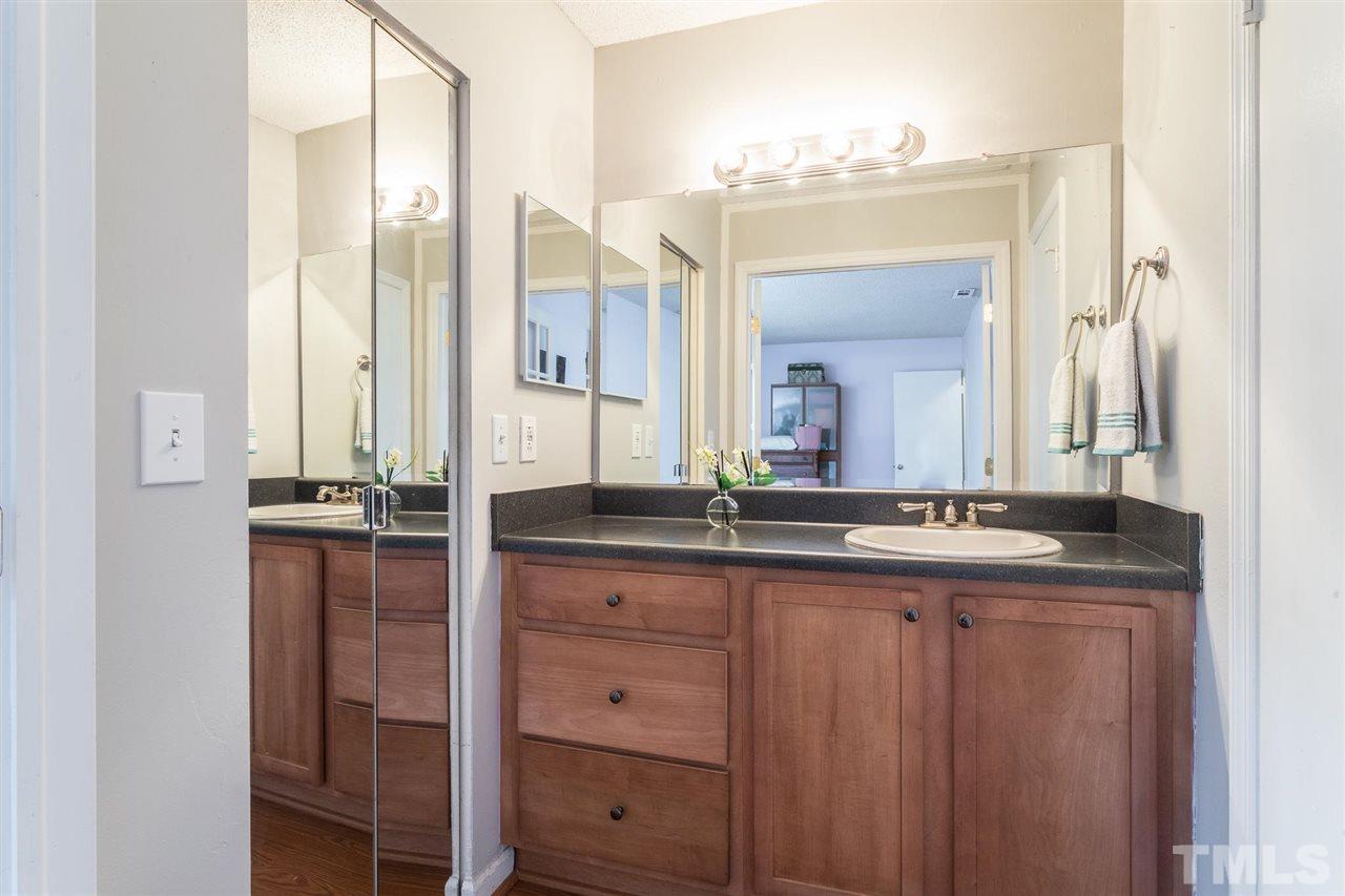 7615 Falcon Rest Circle, Unit 7615 Raleigh, NC 27615 - Photo 24 of 26 a bathroom with a granite countertop sink and a mirror