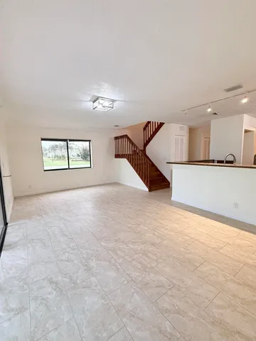 an empty room with a windows and ceiling fan