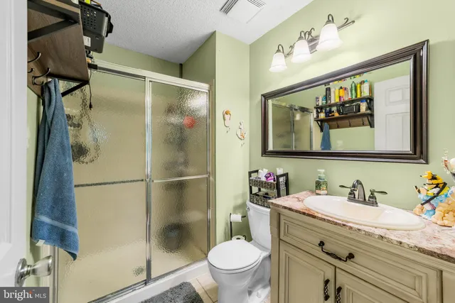 a bathroom with a granite countertop sink toilet and a mirror