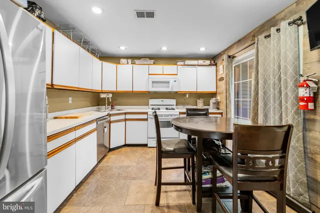 a kitchen with a table chairs sink and cabinets
