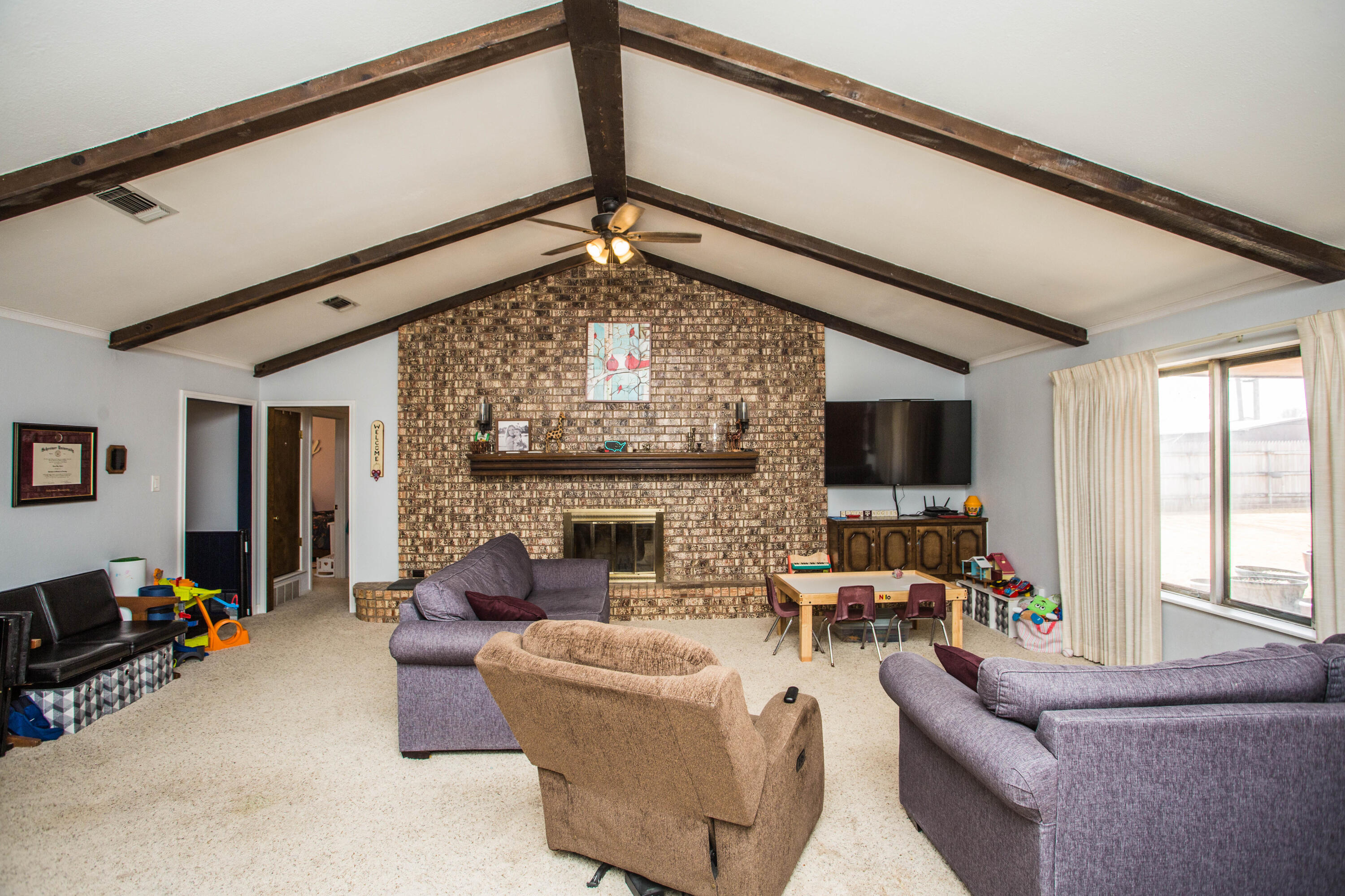 705 South 22nd Street Slaton, TX 79364 - Photo 12 of 30 a living room with furniture and a fireplace