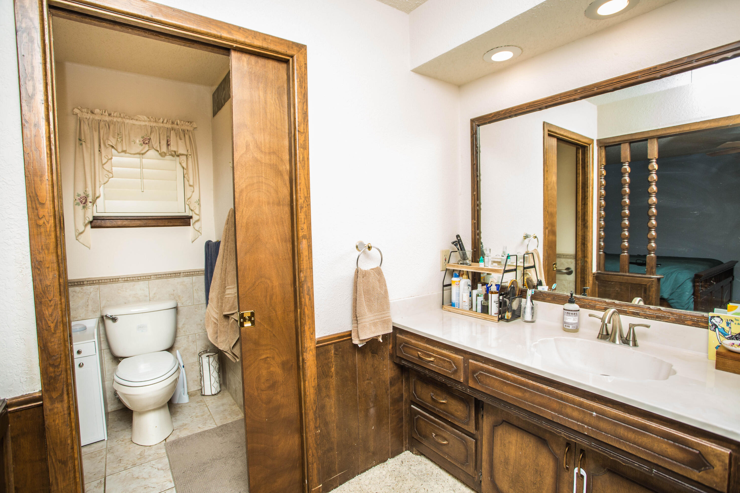 705 South 22nd Street Slaton, TX 79364 - Photo 17 of 30 a bathroom with double vanity sink a mirror and a toilet
