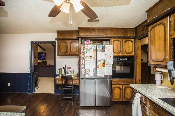 a kitchen with stainless steel appliances granite countertop a sink and a refrigerator
