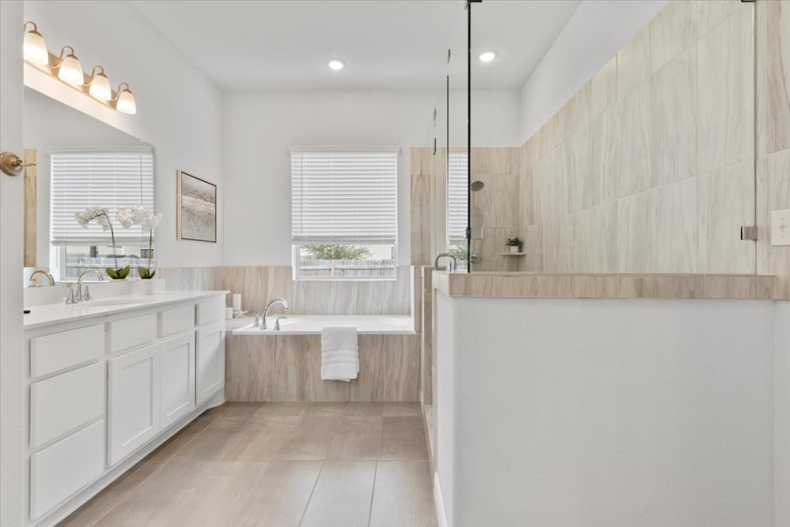 271 Eclipse Drive Austin, TX 78737 - Photo 14 of 39 a bathroom with a double vanity sink a mirror and a bathtub