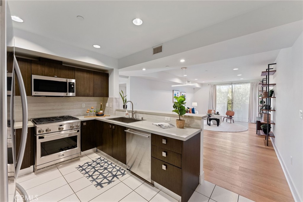 118 North Kings Road, Unit 201 Los Angeles, CA 90048 - Photo 8 of 38 a kitchen with a sink stainless steel appliances and cabinets