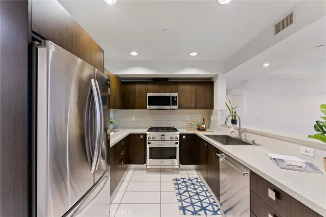 a kitchen with stainless steel appliances a refrigerator sink and stove