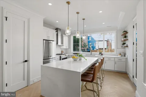 a kitchen with refrigerator and chairs