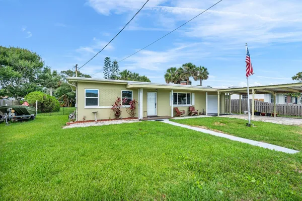 a front view of a house with a yard and trees