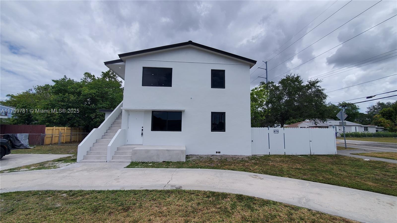 a white house with a tree in the background