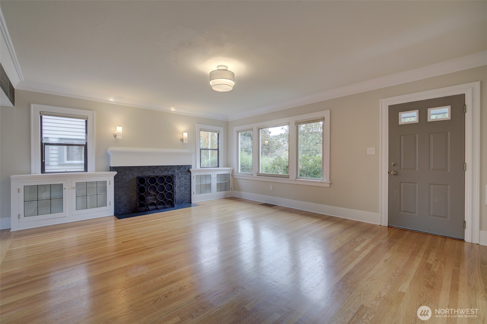 357 29th Avenue Seattle, WA 98122 - Photo 4 of 31 an empty room with wooden floor fireplace and windows