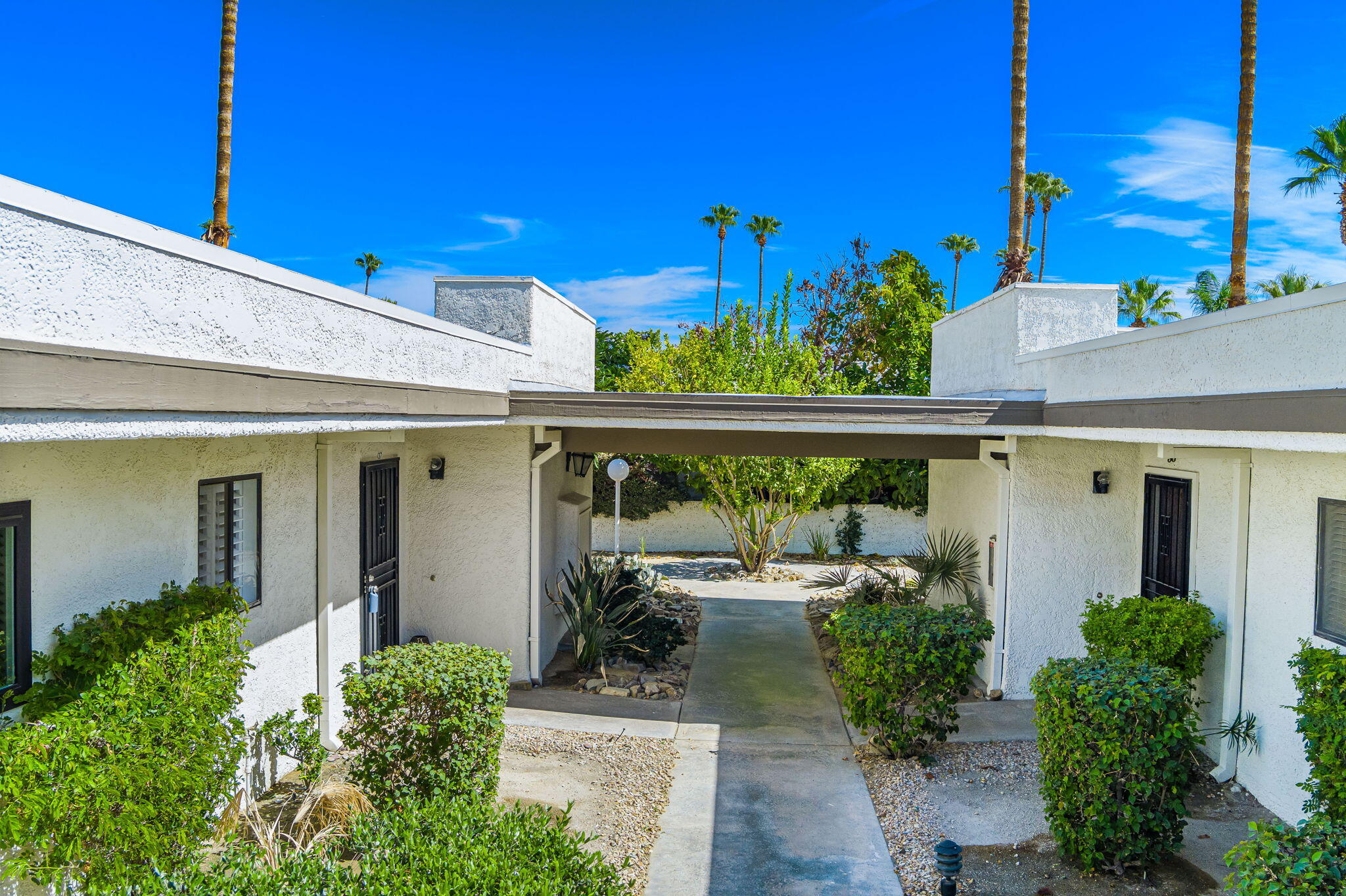 1150 East Palm Canyon Drive, Unit 37 Palm Springs, CA 92264 - Photo 3 of 40 a view of a patio with a table and chairs and potted plants