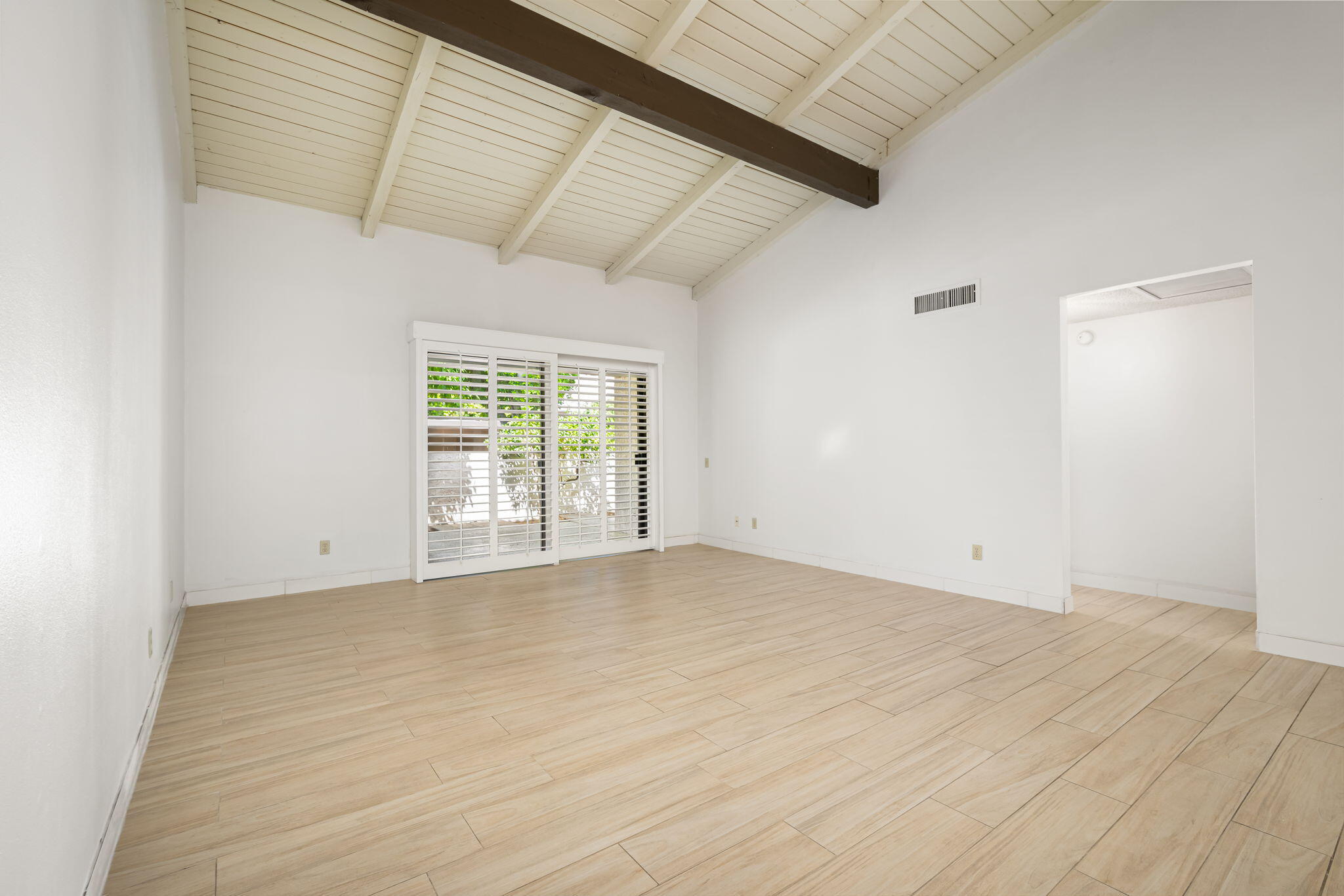 1150 East Palm Canyon Drive, Unit 37 Palm Springs, CA 92264 - Photo 10 of 40 an empty room with wooden floor and windows