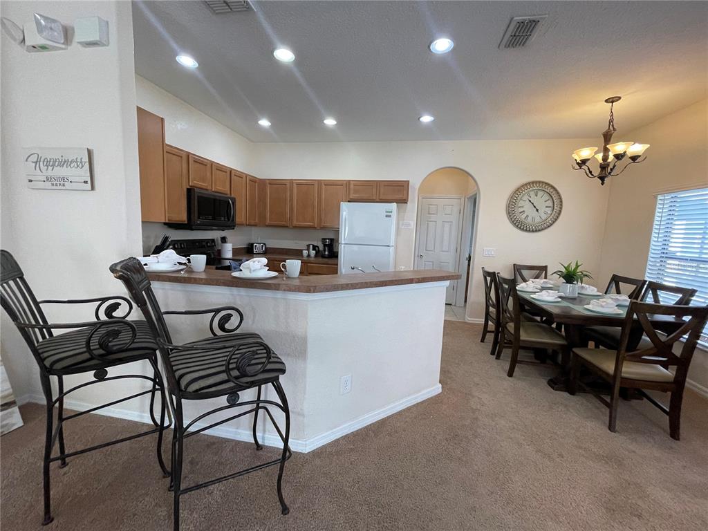 141 Summer Pl Loop Clermont, FL 34714 - Photo 16 of 63 a living room with furniture a clock and a view of kitchen