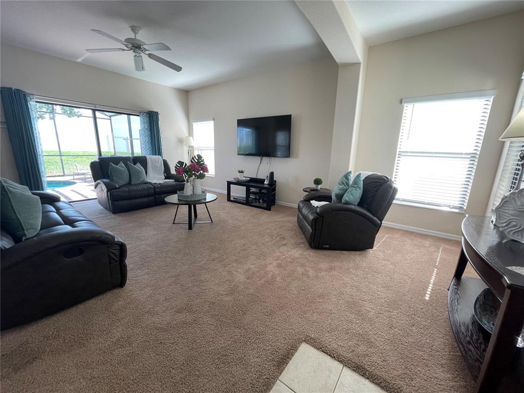 141 Summer Pl Loop Clermont, FL 34714 - Photo 9 of 63 a living room with furniture a flat screen tv and a large window