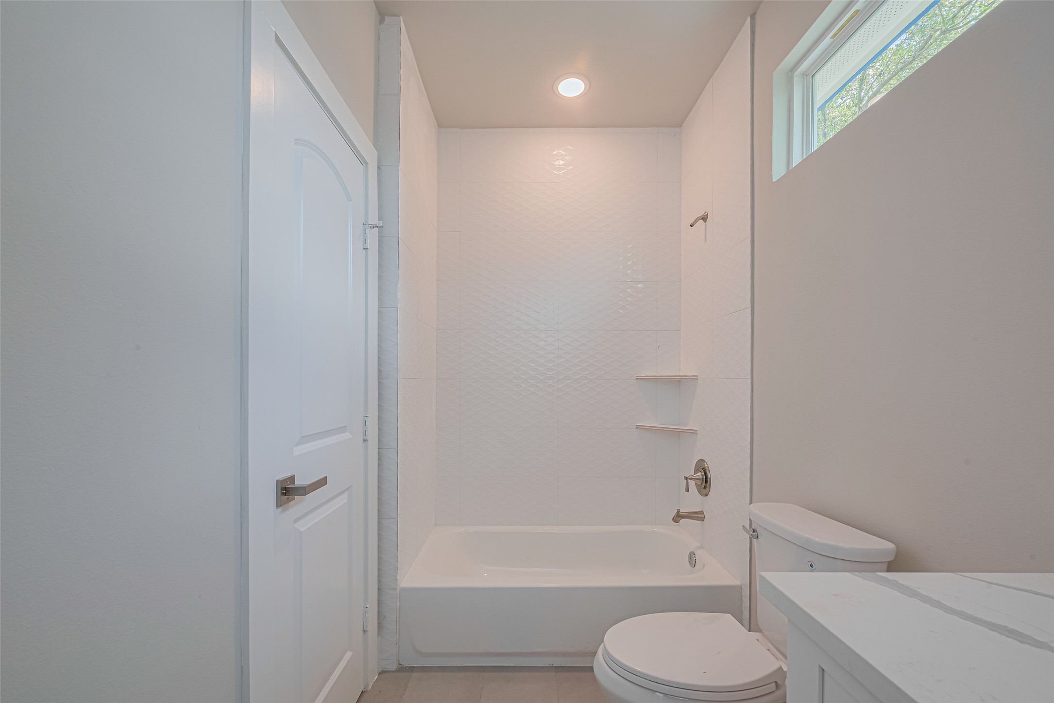 7207 Force Street Houston, TX 77020 - Photo 20 of 29 This bathroom features a white bathtub and shower combo, and a sleek toilet.
