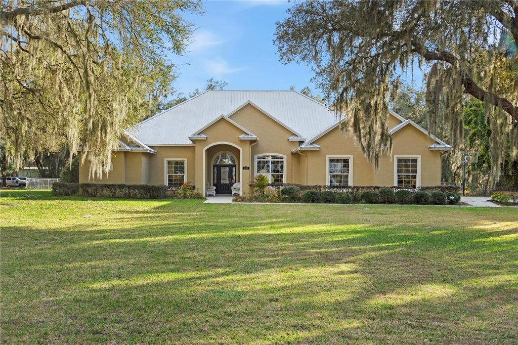 3108 Carter Jones Road Groveland, FL 34736 - Photo 1 of 54 a front view of a house with a garden