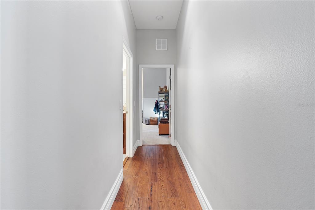 3108 Carter Jones Road Groveland, FL 34736 - Photo 25 of 54 a view of a hallway with wooden floor and a white wall