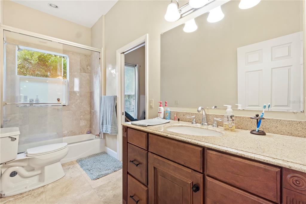 3108 Carter Jones Road Groveland, FL 34736 - Photo 26 of 54 a bathroom with a granite countertop sink toilet mirror vanity and bathtub
