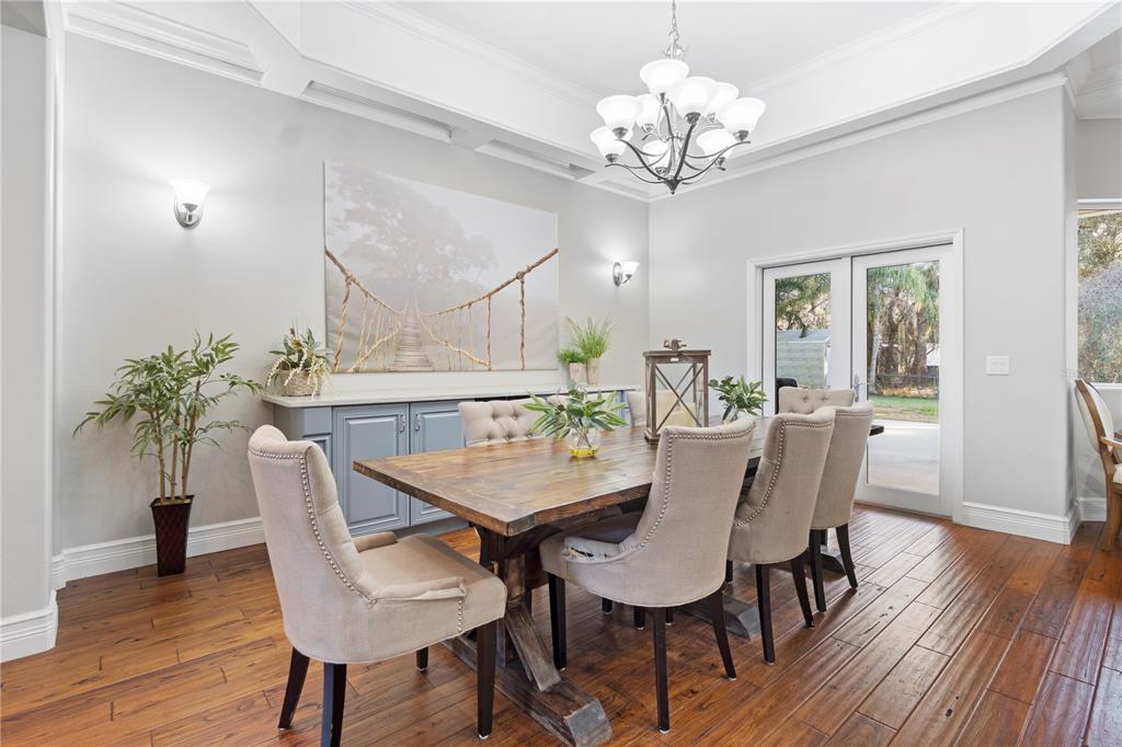 3108 Carter Jones Road Groveland, FL 34736 - Photo 9 of 54 a view of a dining room with furniture a chandelier and wooden floor