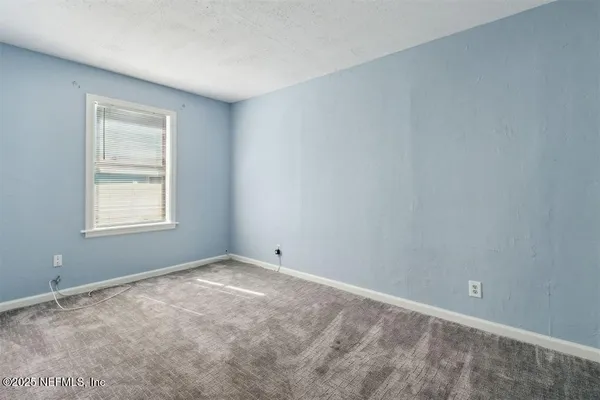 a kitchen with white cabinets and window