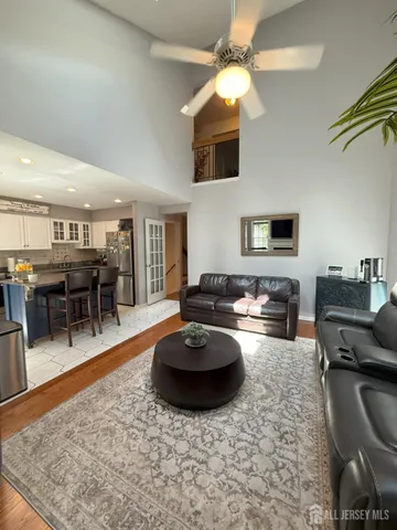 a living room with furniture a flat screen tv and kitchen view
