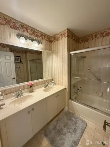 a bathroom with a shower sink and mirror
