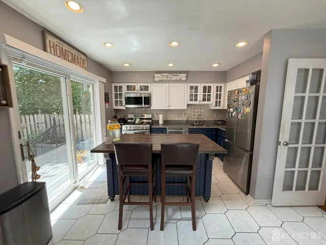 a kitchen with stainless steel appliances granite countertop a refrigerator and a sink