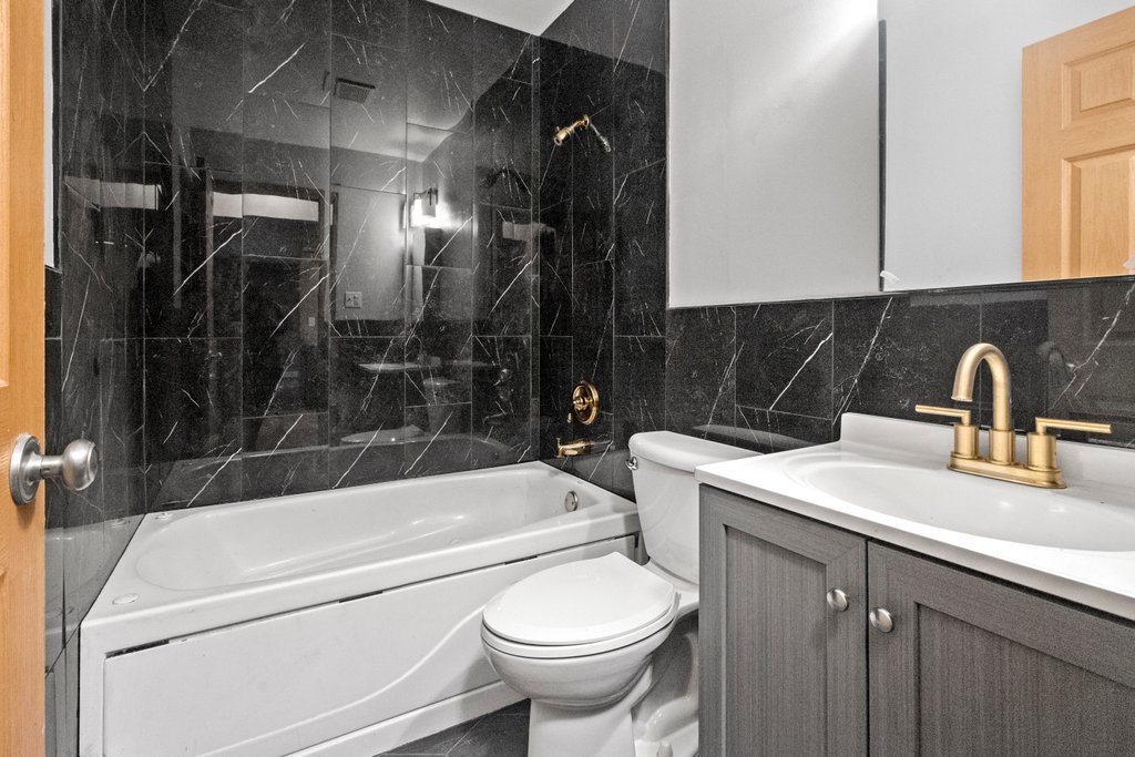 14501 Keystone Avenue, Unit 12 Midlothian, IL 60445 - Photo 8 of 11 a bathroom with a sink a toilet and shower