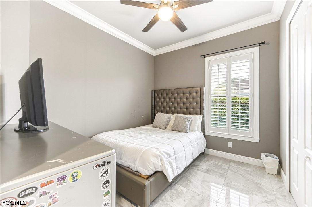 1700 43rd Terrace Southwest Naples, FL 34116 - Photo 10 of 38 a bedroom with a bed and a flat tv screen on the dresser