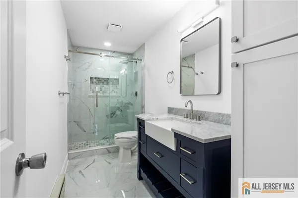 a bathroom with a granite countertop sink toilet and shower