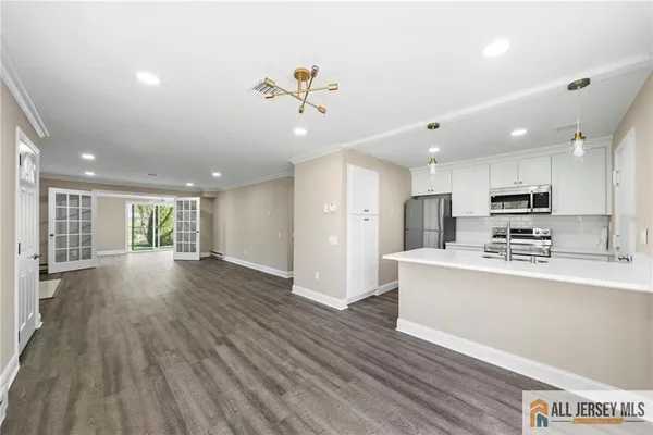 a view of kitchen with sink a refrigerator and wooden floor