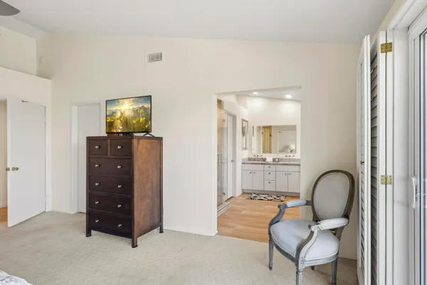 a bedroom with a large bed and a chandelier