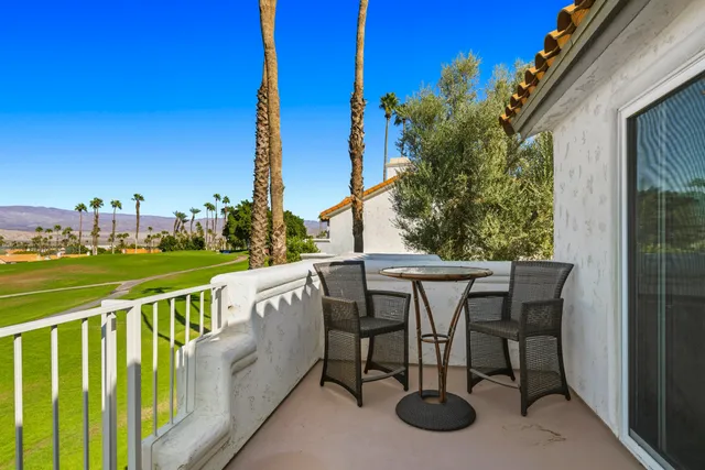 a view of a swimming pool and lounge chairs in back yard of the house