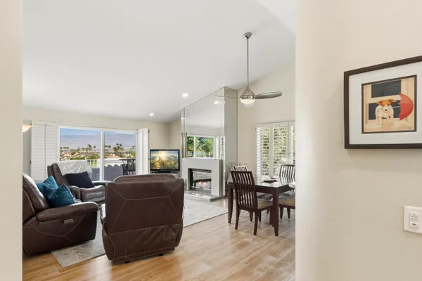 a living room with furniture a large window and kitchen view