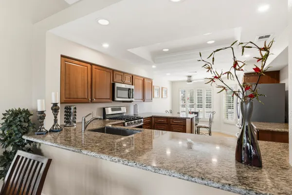 a kitchen with granite countertop a sink and a stove top oven